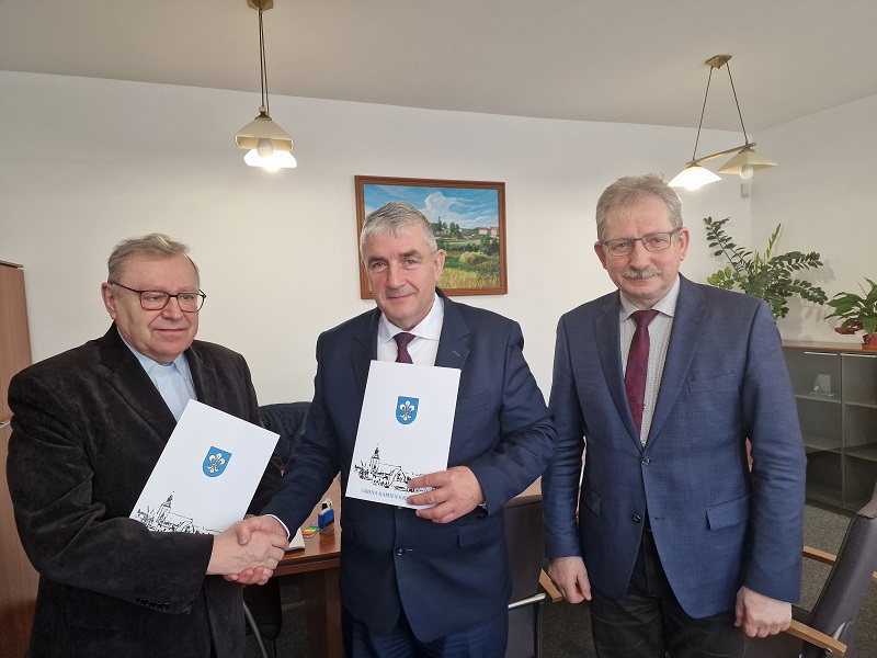 zdjęcie przedstawia ks. prałata Eugeniusza Peplińskiego, burmistrza Kamienia Krajeńskiego Wojciecha Głomskiego oraz skarbnika miasta ii gminy Piotra Gustyna podczas przekazania umów dotacji